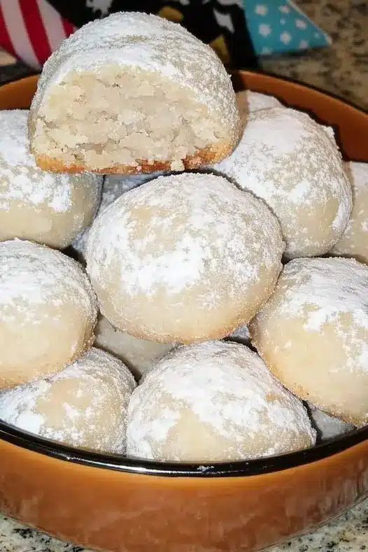 A beautiful arrangement of pecan snowball cookies on a festive holiday tray.