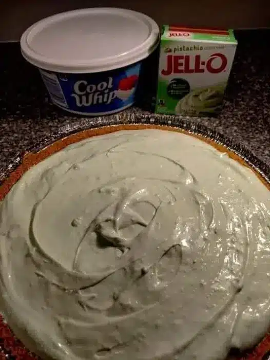 The finished Easy Pistachio Fluff Salad served in a glass bowl with a cherry on top