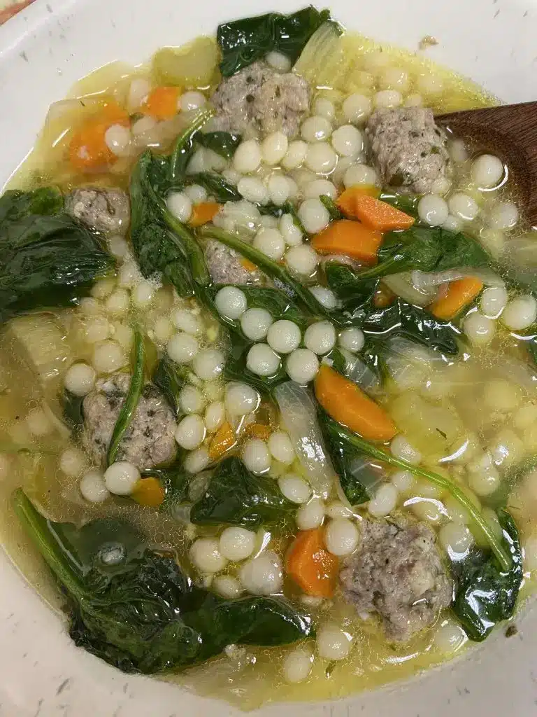 Freshly served Italian wedding soup with a side of crusty bread