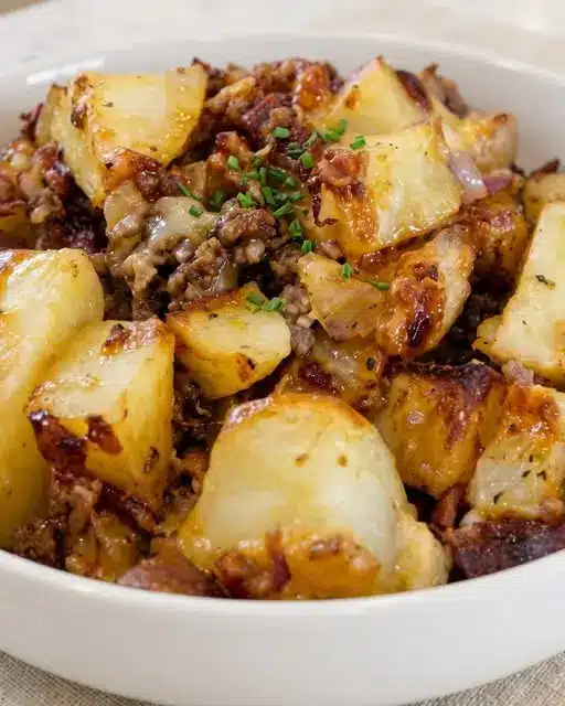 Full skillet of BBQ cheeseburger potatoes garnished with fresh herbs