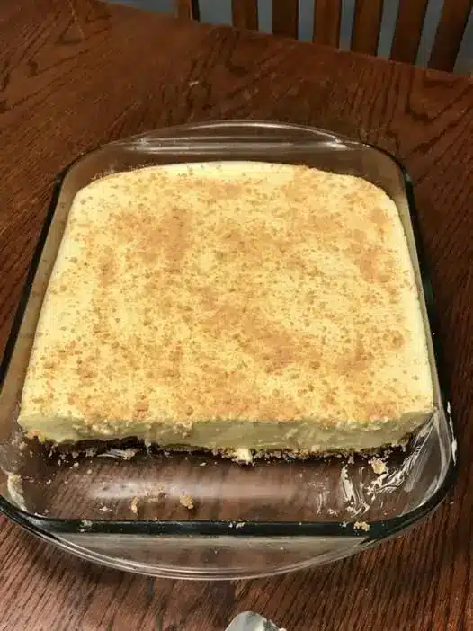 The finished banana pudding cake sliced and served on a plate with extra wafers