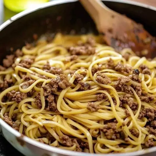 A close up of braised beef shank and noodles in a rich dark broth