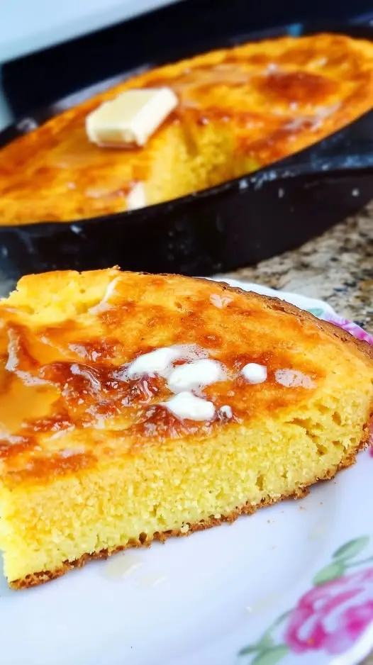 Slices of golden brown skillet cornbread served with butter and honey