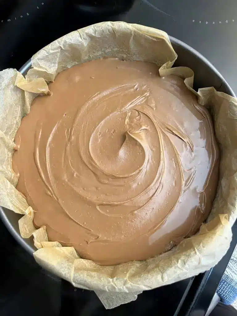 A sliced chocolate basque cheesecake showing the creamy, soft interior and dark exterior