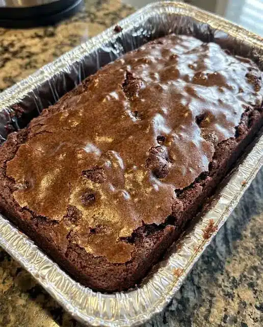 A stack of thick, chewy chocolate chip cookie bars showing the fudgy center
