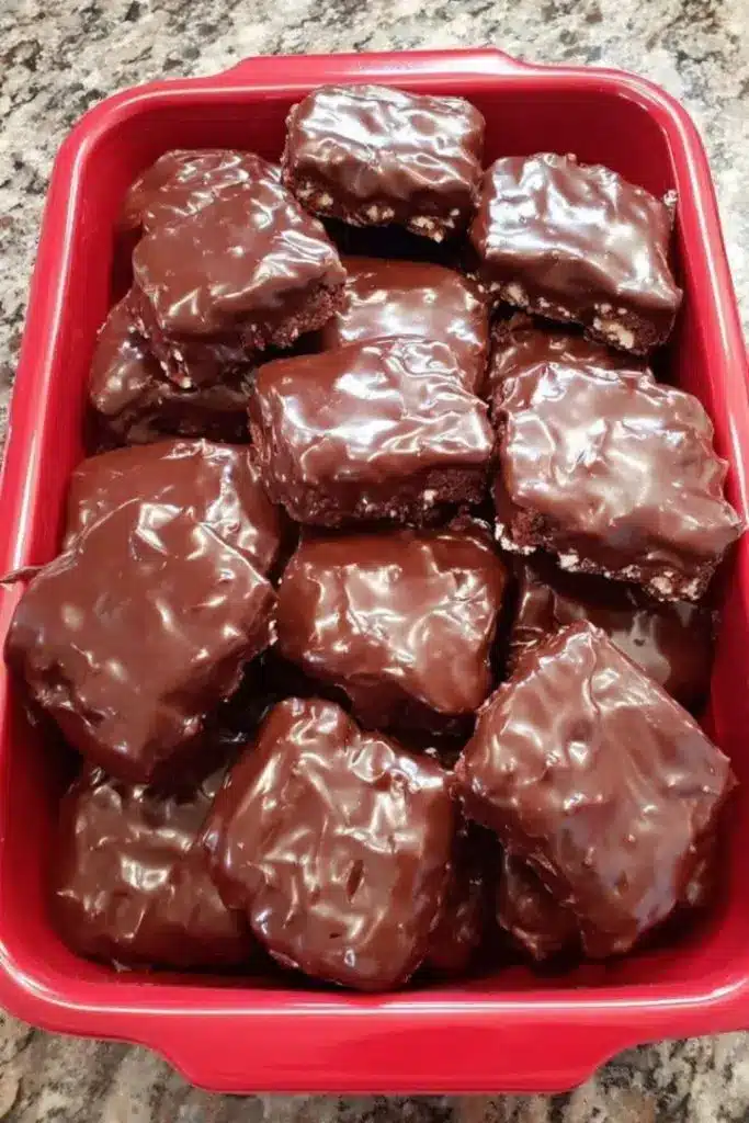 A stack of chocolate covered brownie bars showing the fudgy interior and snappy outer shell