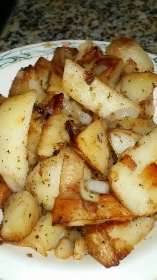 The finished crispy fried potatoes served on a plate with a side of dipping sauce