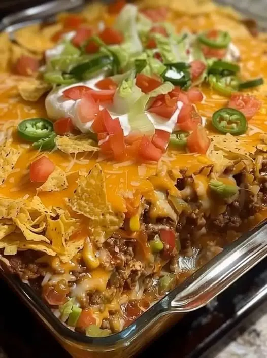 The finished taco casserole served with fresh toppings like lettuce and sour cream