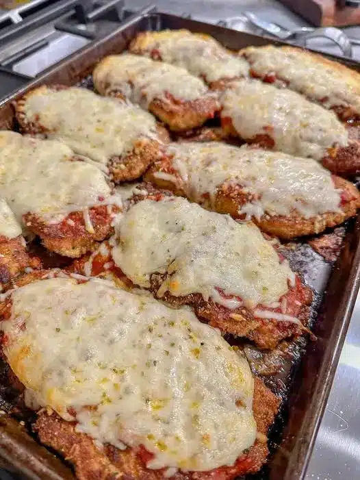 The finished best homemade chicken parmesan served over spaghetti