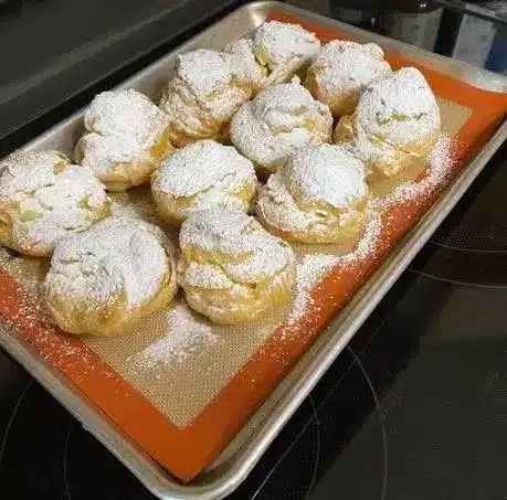 Assembled cream puffs filled with vanilla pastry cream and dusted with powdered sugar