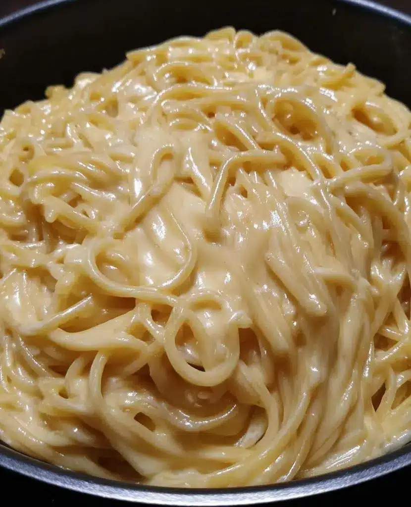 A bowl of creamy garlic parmesan pasta served with a side of crusty bread