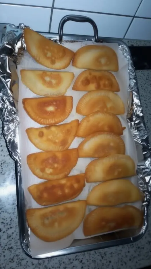 Close up of a bitten fried hand pie showing the chunky apple filling inside