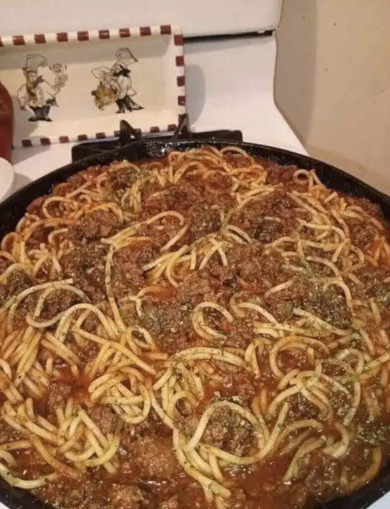A perfectly plated serving of homemade spaghetti with meat sauce topped with fresh parmesan and basil.