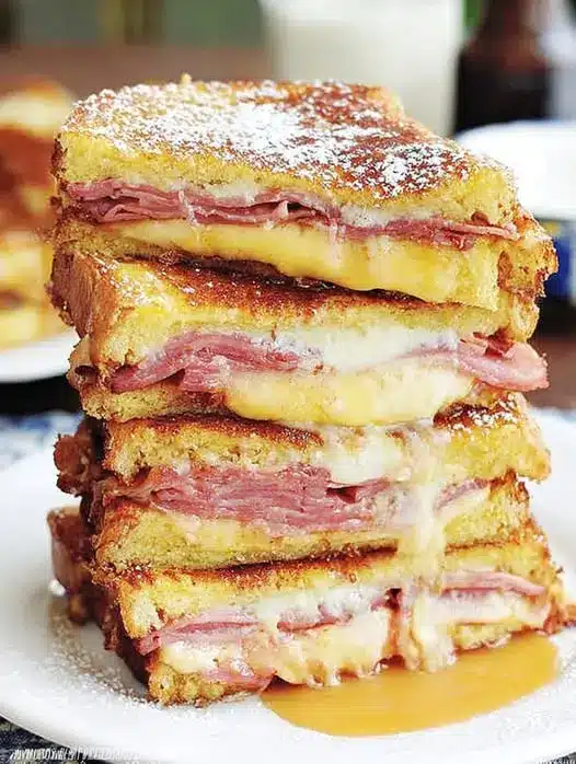 The finished Monte Cristo sandwich cut in half with melted cheese