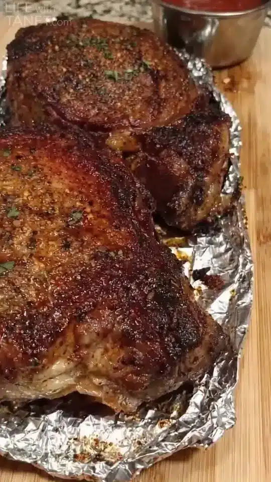 Slices of perfectly cooked medium-rare roast beef served on a platter with roasted vegetables.