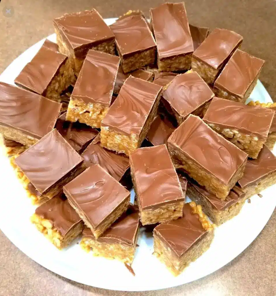 Stacked scotcheroo bars showing the thick cereal base and the smooth duo-toned chocolate layer.