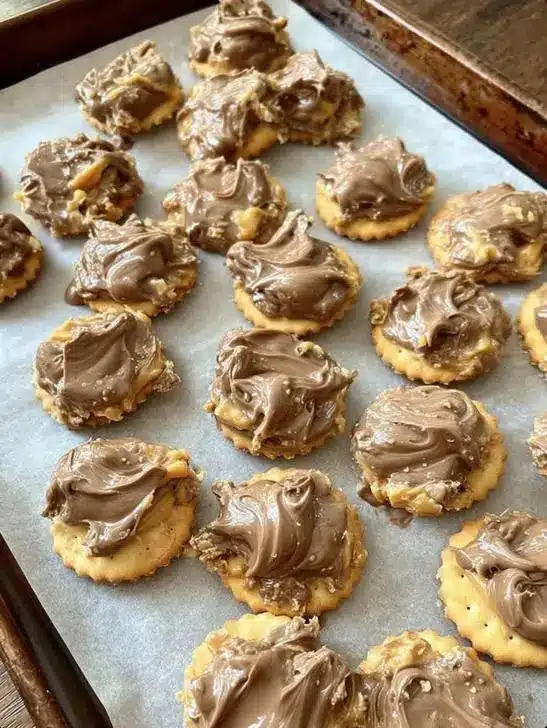 A stack of golden brown pecan dandy cookies on a cooling rack, showing the pecan half pressed into the center.