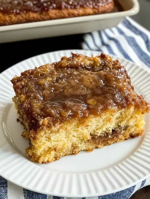A whole southern pecan cake on a pedestal, showing its golden brown exterior