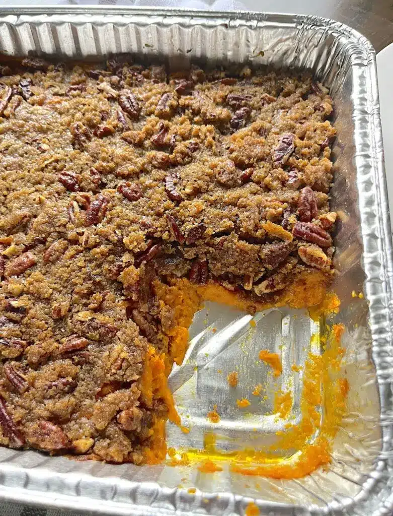 The finished sweet potato casserole in a white baking dish with golden brown pecan topping
