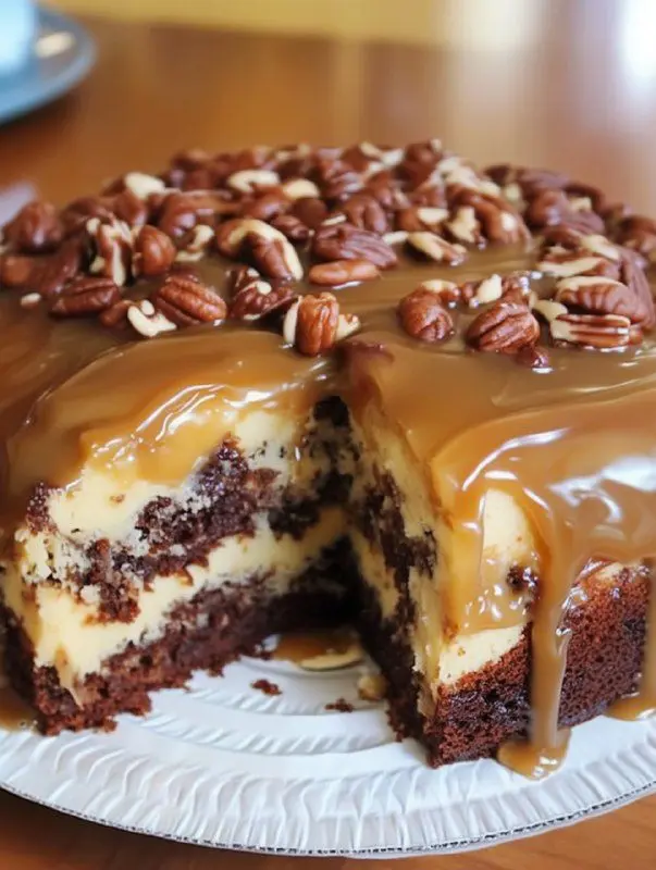 A slice of turtle caramel cake on a white plate, showing the chocolate layers, caramel filling, and pecan pieces.