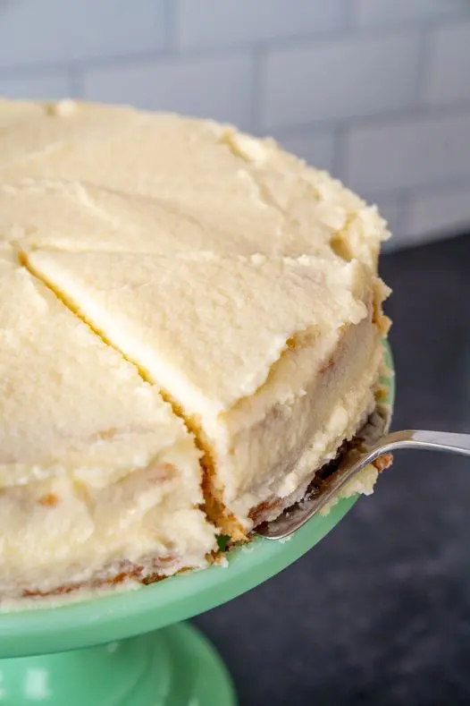 Slice of white velvet cake with vanilla bean buttercream on a white plate