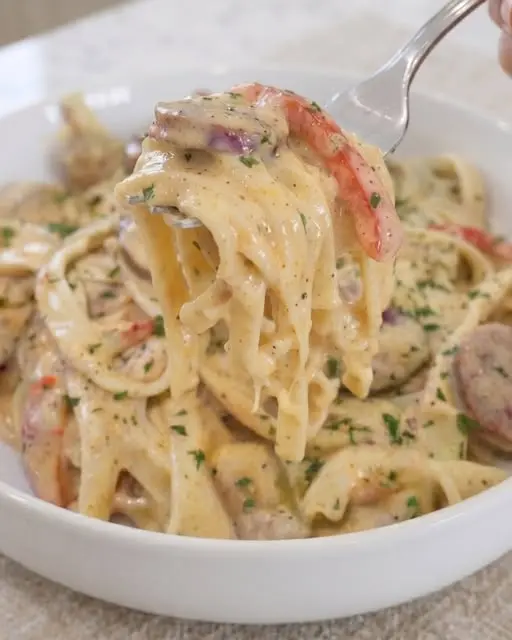 A bowl of Cajun chicken sausage pasta topped with fresh parsley