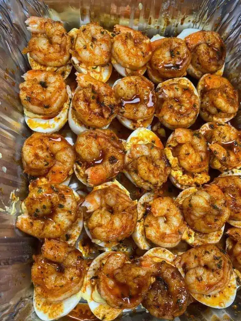 Close up of a single Cajun shrimp deviled egg showing the creamy texture and seared shrimp.