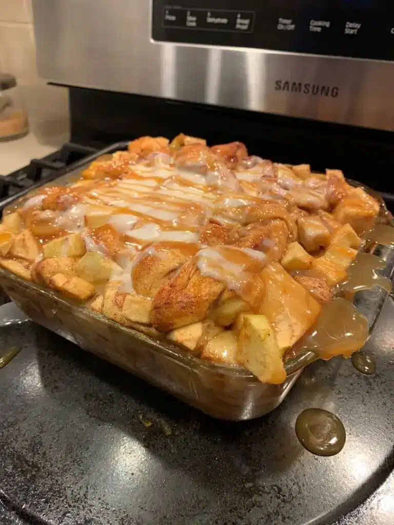 A sliced portion of caramel apple cinnamon roll lasagna on a white plate