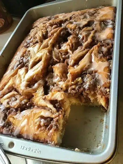 A slice of caramel apple sheet cake served on a plate with a dollop of whipped cream