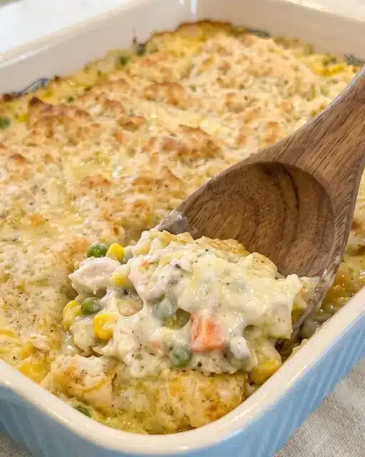 a serving of golden chicken casserole on a white plate showing the creamy interior