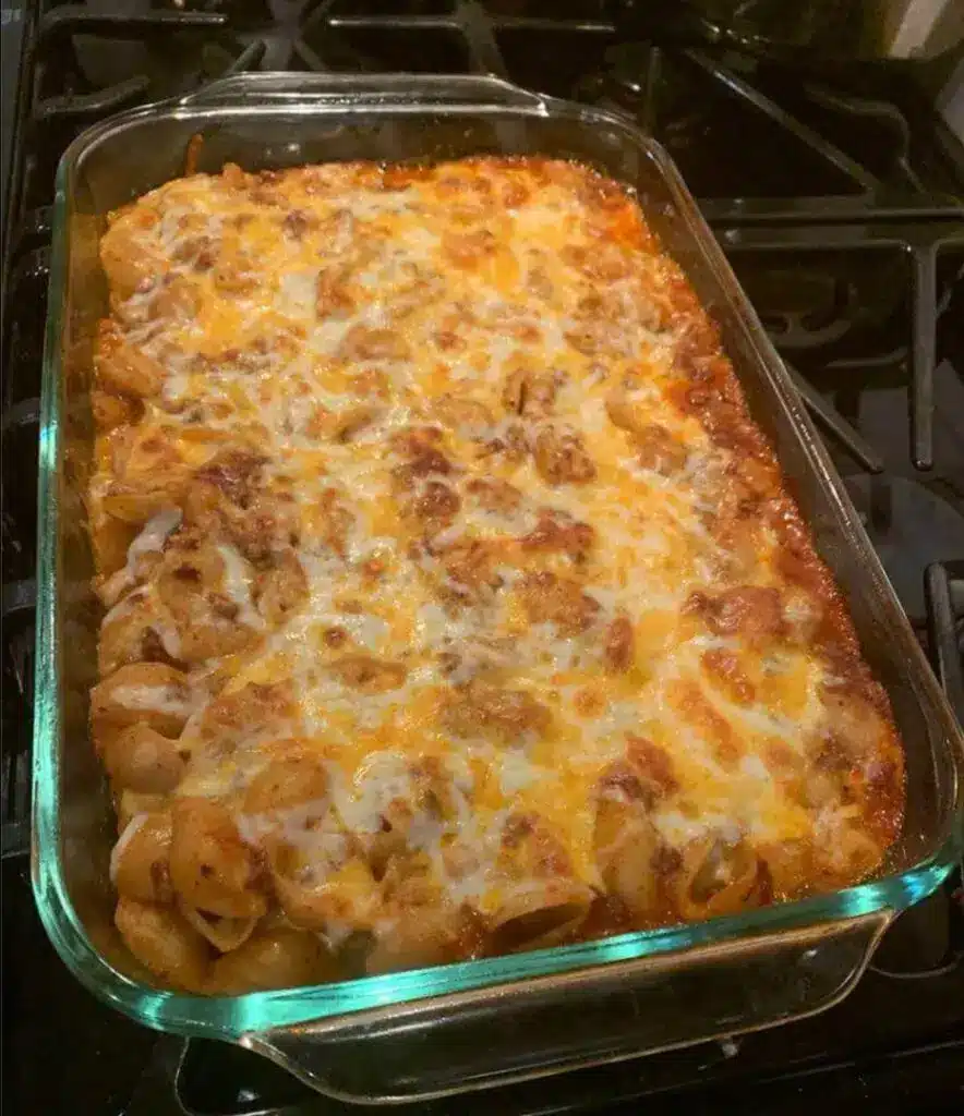 A serving of cheesy hamburger potato casserole on a plate with fresh parsley garnish.