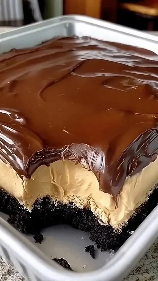 a single slice of chocolate peanut butter lasagna on a white plate showing all four layers