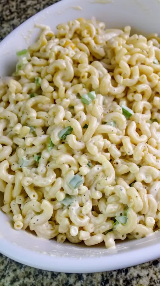Close up of creamy macaroni salad garnished with fresh parsley.