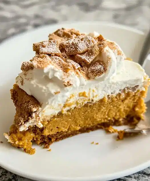 A slice of pumpkin pie served with a dollop of whipped cream