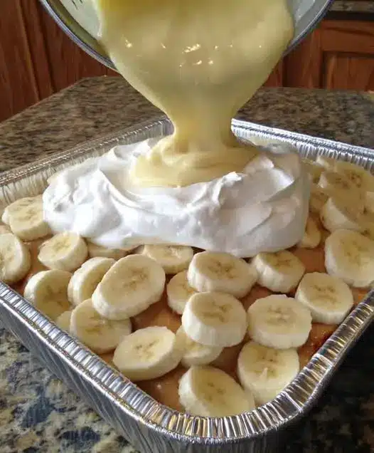 A scoop of banana pudding on a plate showing the soft cookies and creamy layers.