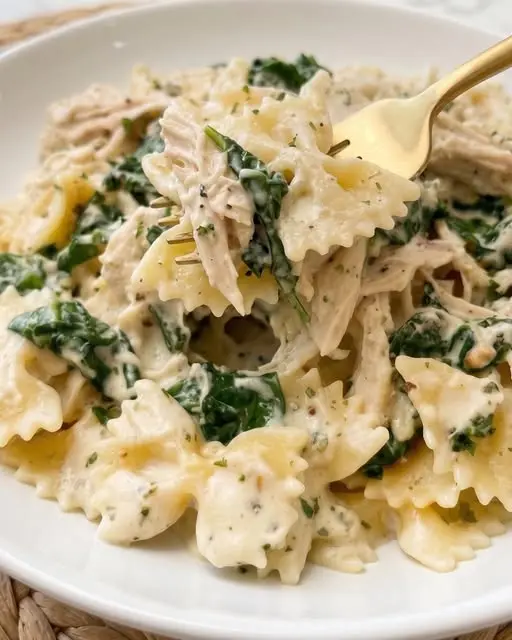 Plate of Boursin chicken pasta garnished with parmesan and fresh parsley