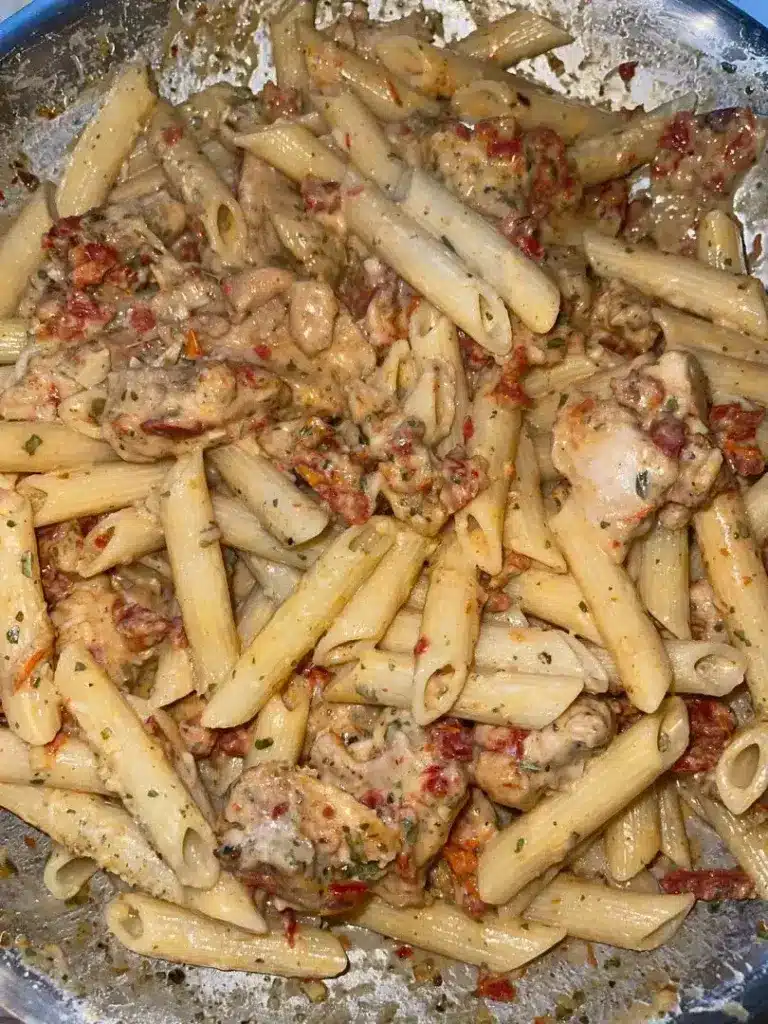 The finished creamy chicken mozzarella pasta served in a bowl with a garnish of herbs