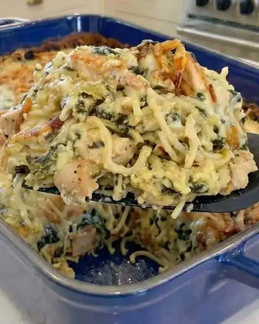 The finished creamy Monterey chicken spaghetti bake in a ceramic dish, topped with melted cheese and bacon