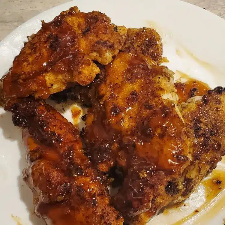 The finished crispy honey garlic chicken served over white rice with sesame seeds