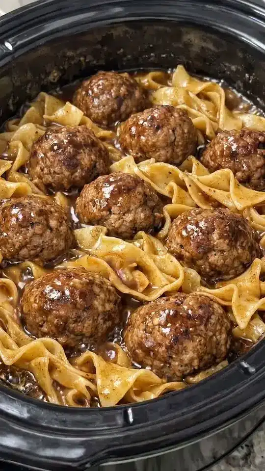 Beef and noodles served in a white bowl garnished with fresh parsley