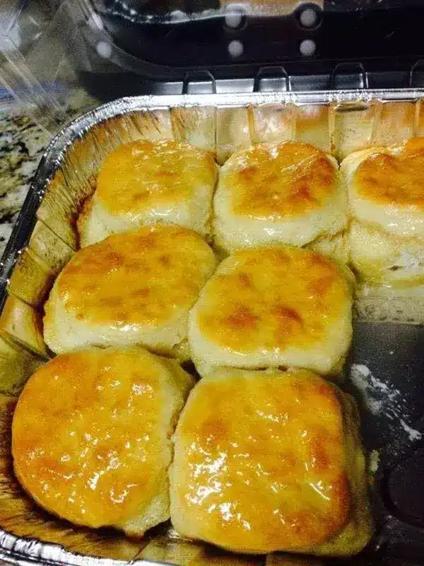 A tray of golden brown 7-Up biscuits fresh out of the oven, showing their fluffy texture and crispy edges.