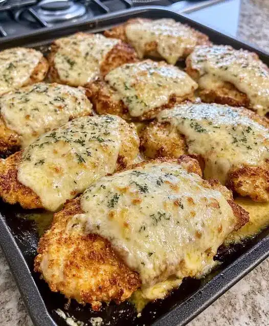 The finished easy baked parmesan chicken served on a plate with a side salad