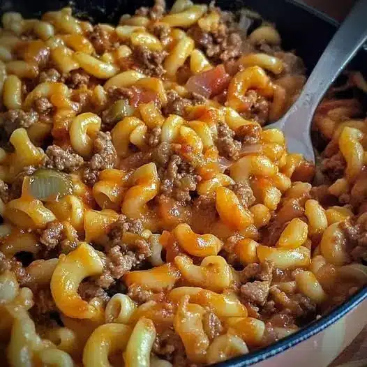 The finished beef macaroni skillet served on a plate with a side of garlic bread.