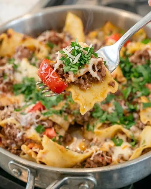 Finished beef mushroom skillet lasagna served in a pan with melted cheese and fresh herbs.