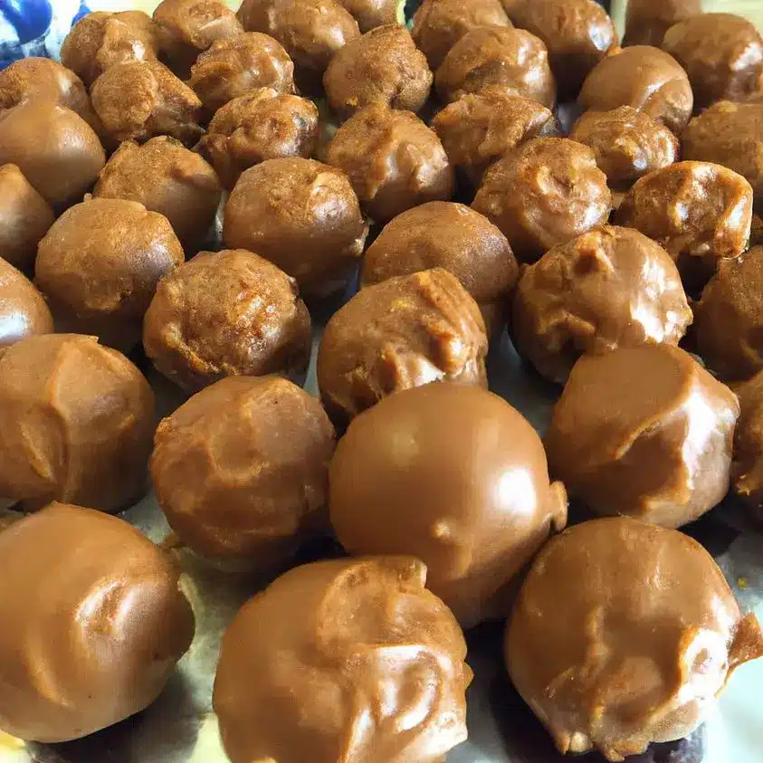 Finished chocolate-covered peanut butter balls topped with candy crumbs