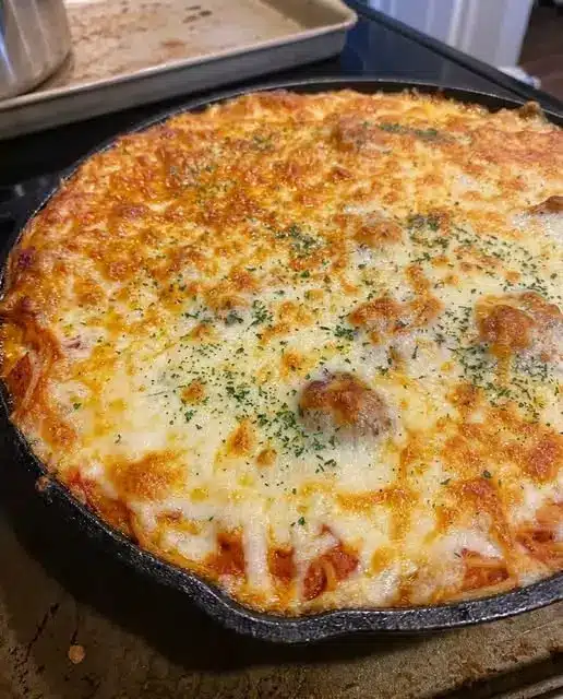 A close-up of a cracker being dipped into a thick, stretchy melted cheese dip.