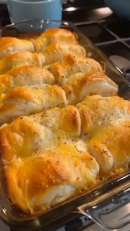 Close up of a fork lifting cheesy chicken and broccoli from a pan