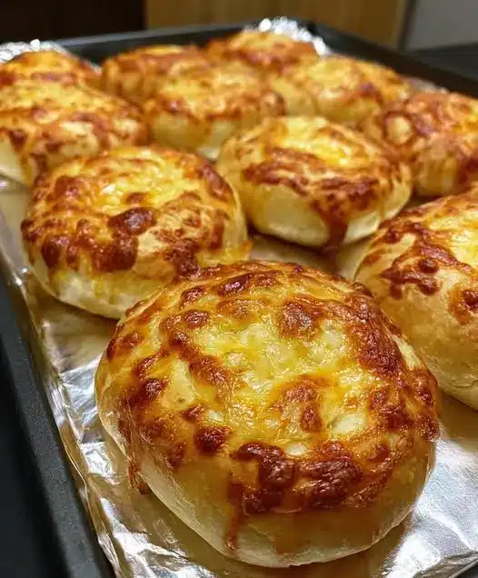 Overhead view of cheesy garlic bread rolls in a baking dish