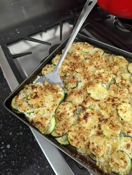 The finished cheesy zucchini casserole in a white baking dish with a golden brown crust