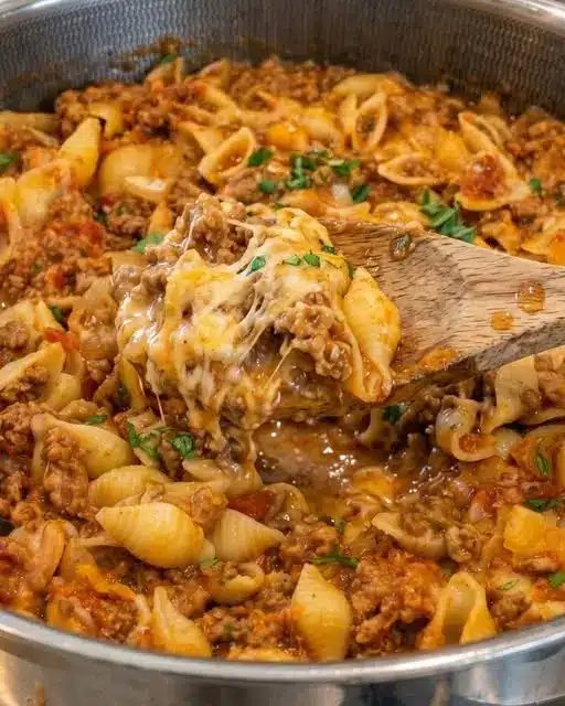 Finished taco pasta served in a bowl topped with fresh cilantro and sour cream